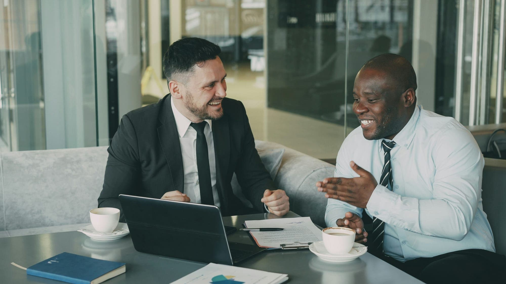 Two business owners talking over coffee at a café table